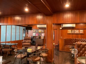 ไม้แดงกรุผนังภายในคาเฟ่โรงคั่วกาแฟ โดยจัดคู่กับเฟอร์นิเจอร์หนังสีเข้ม